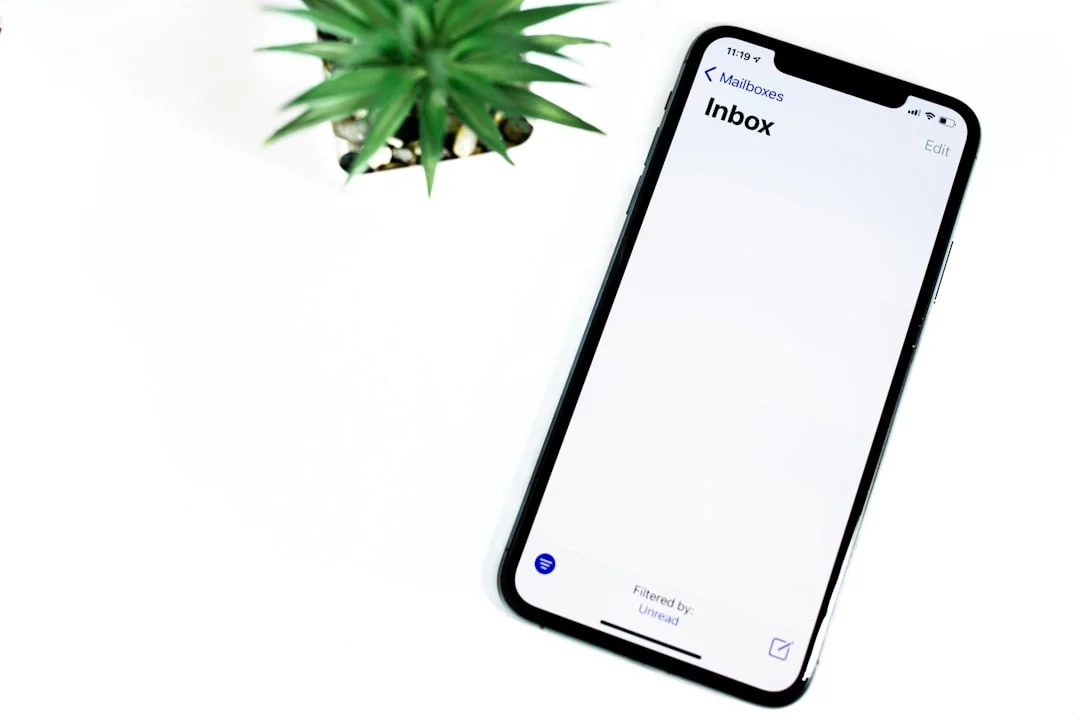 Un espace de travail moderne où des mains examinent des données marketing sur un ordinateur portable et des documents papier.